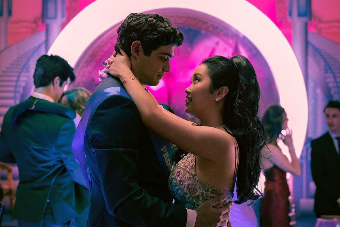 a young man and woman slow dance at a highschool prom